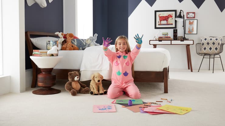 girl plays with finger paints on her stain-resistant carpeted bedroom floor